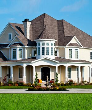 A large white house with a lush green lawn.
