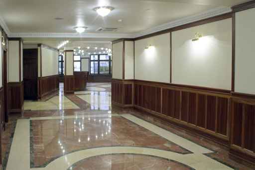 A large hallway with marble floors and walls.