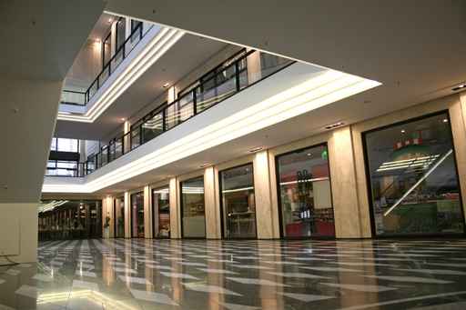 A large building with many windows and lights on the ceiling.