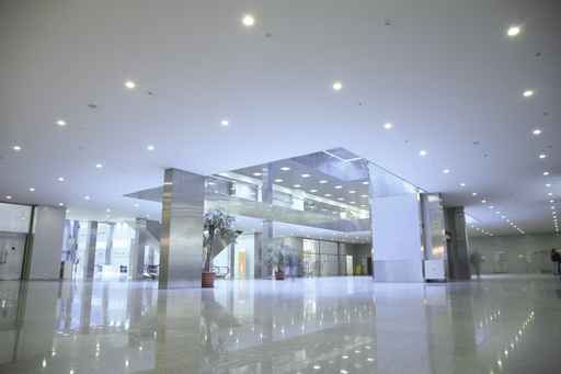 A large white lobby with many lights on the ceiling.